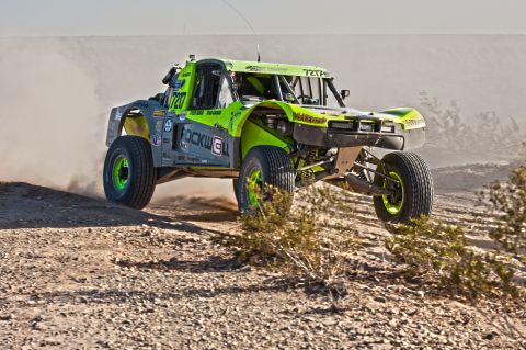 1996 Ford Bronco - Off-road race truck with number 7217 navigates a dusty desert terrain.