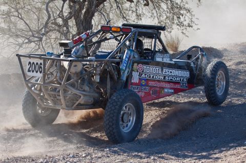 1996 Ford Bronco - A custom-built off-road buggy races across a dusty, desert terrain.