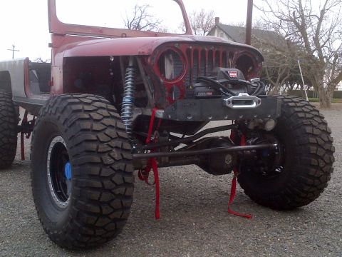 1985 Jeep CJ7 - This modified Jeep CJ-series features oversized tires and a front-mounted winch, suggesting off-road customization.