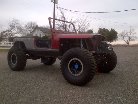 1985 Jeep CJ7 - This modified Jeep CJ-series features oversized tires and custom body modifications, suggesting a build focused on off-road capability.
