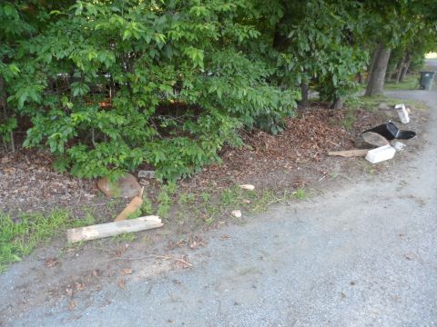 1971 Ford Ranchero - The roadside is littered with various objects, including broken wood and rocks, near a line of trees.