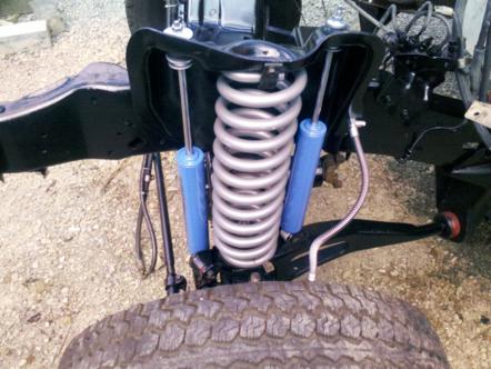 1982 Ford Bronco - Close-up of front suspension components, including a coil spring and shock absorber.