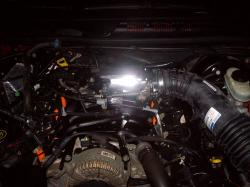 2004 Ford Crown Victoria - A view of the engine bay, showing various components including the air intake system and alternator.