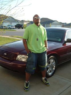 2004 Ford Crown Victoria - A man poses in front of a red 2004 Ford Crown Victoria, captured in a 3q front view.