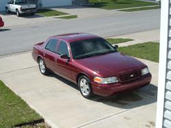 2004 Ford Crown Victoria - Maroon 2004 Ford Crown Victoria parked on a concrete driveway on a sunny day.