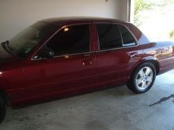 2004 Ford Crown Victoria - Side view of a maroon sedan parked in a garage. The specific year of the vehicle is not discernible from the image.