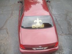 2004 Ford Crown Victoria - Rear view of a maroon 2004 Ford Crown Victoria with a gold New Orleans Saints decal on the back window.