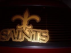 2004 Ford Crown Victoria - A gold New Orleans Saints logo is affixed to the rear window of a vehicle.