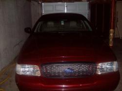 2004 Ford Crown Victoria - Front view of a dark red 2004 Ford Crown Victoria parked inside a garage.