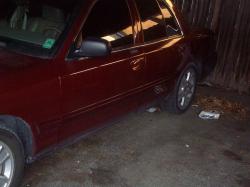 2004 Ford Crown Victoria - A maroon 2004 Ford Crown Victoria is seen from the side, parked in an outdoor area.