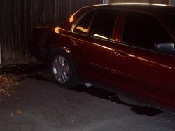 2004 Ford Crown Victoria - A dark red sedan is parked outdoors, showing its side profile and chrome wheels.