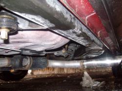 2004 Ford Crown Victoria - A low-angle view of a vehicle's undercarriage, showing the exhaust system and suspension parts.