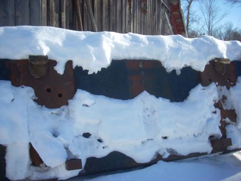 1963 Hummer H3 - A close-up view of a heavily rusted metal component, partially obscured by snow, with the Supermotors logo visible at the bottom right.