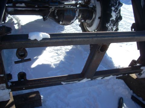 1963 Hummer H3 - Close-up of a tractor's rear axle and frame assembly covered in snow.