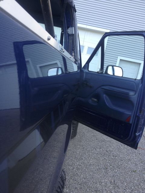 1996 Ford Bronco - Interior view of a blue SUV, focusing on the open driver's side door and dashboard details.