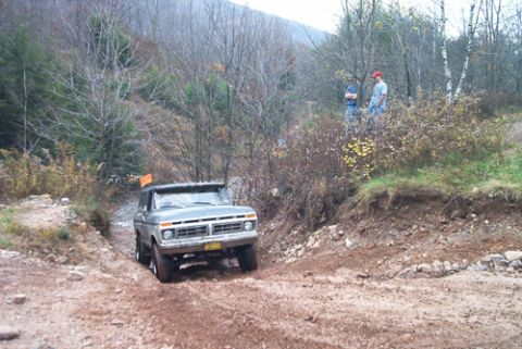 1979 Ford Bronco - A 1975 Ford F-Series truck navigates a challenging, muddy off-road course.