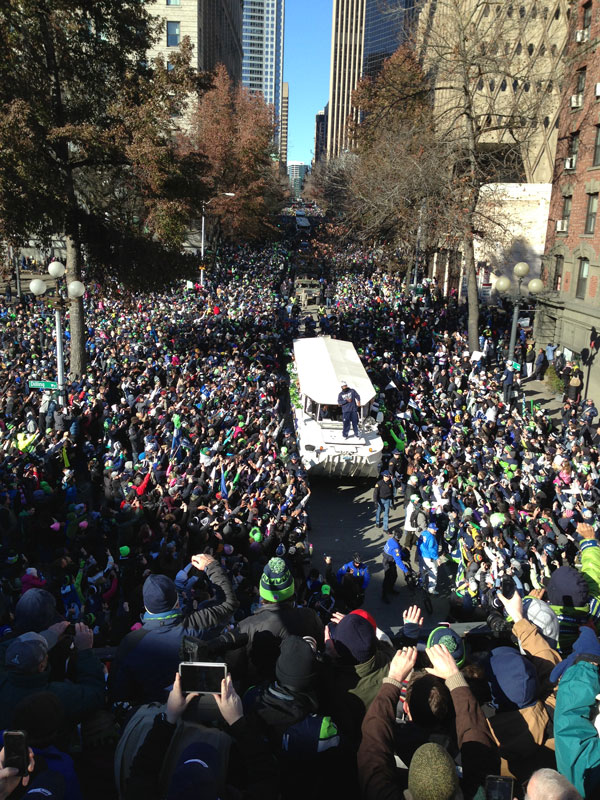 Parade float with people surrounded by a large crowd