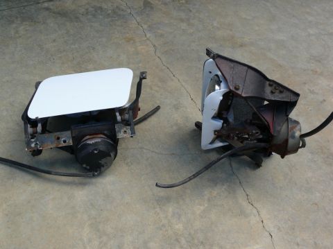 1976 Chevrolet Corvette - Two headlight assemblies, one with a white cover, are shown on a concrete surface.