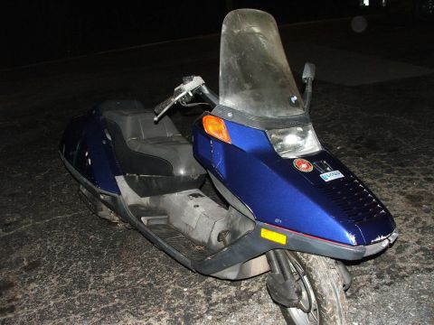 2006 Honda Reflex - A blue scooter is parked on a cracked asphalt surface at night.