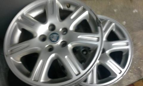 1998 Ford Crown Victoria - Two Jaguar alloy wheels are shown, each with a Jaguar emblem.