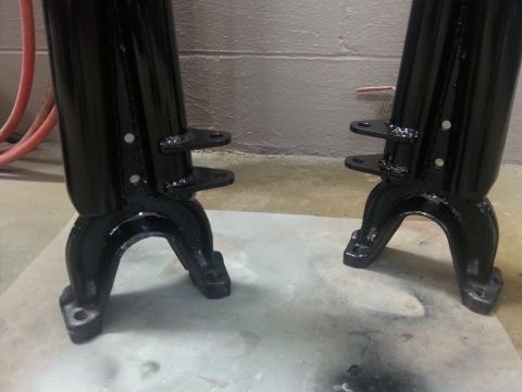 1996 Ford Bronco - Two black metal automotive parts are shown, likely differential components, on a concrete surface.