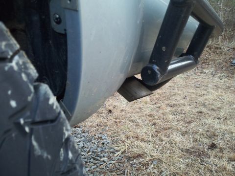 2003 Nissan Frontier - Exhaust pipe and aftermarket bumper guard visible on a vehicle.