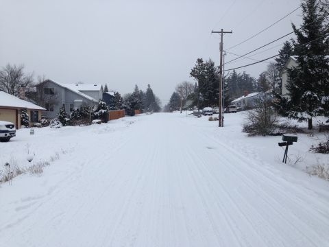 1992 Ford F-150 - A quiet, snow-covered street in a residential neighborhood with several vehicles parked along the side.