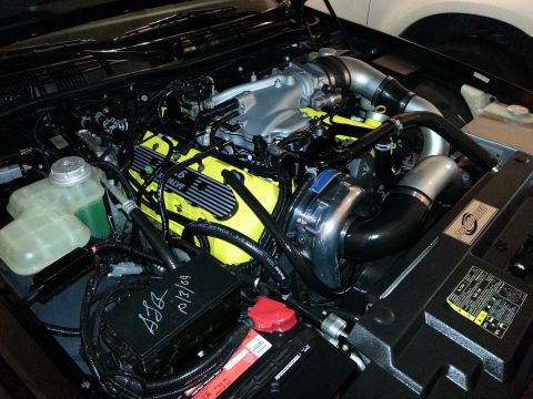 2003 Mercury Marauder - Close-up view of a modified engine bay, a prominent supercharger and custom yellow valve covers.