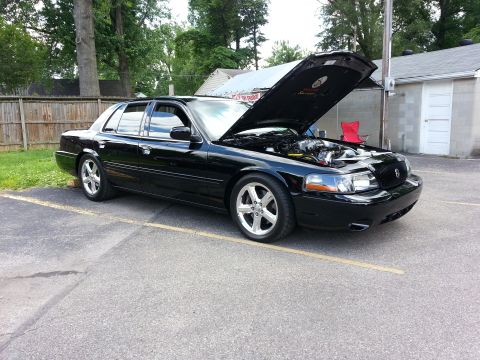 2003 Mercury Marauder - A black 2003 Mercury Marauder sedan is parked outside with its hood raised, revealing the engine compartment.