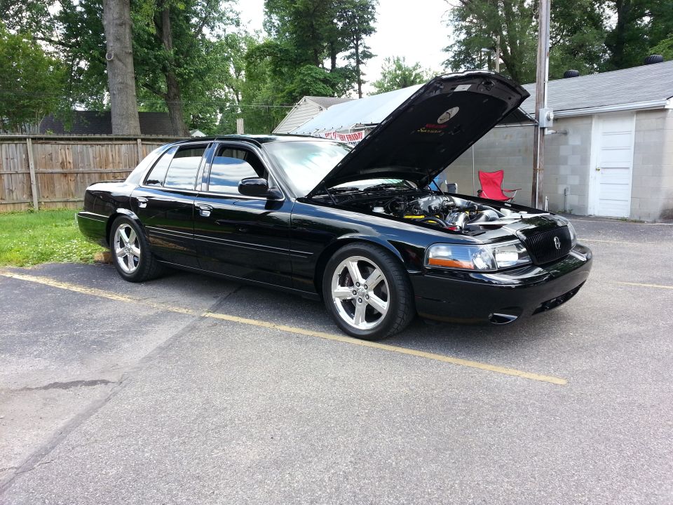 Black 2003 Mercury Marauder sedan parked with hood open, showing engine