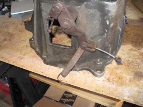 1966 Ford Falcon - A close-up view of a transmission part with a rusty linkage and cable attached.