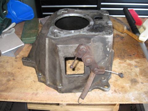 1966 Ford Falcon - A close-up view of a used transmission case with its shifter mechanism and a spring attached.