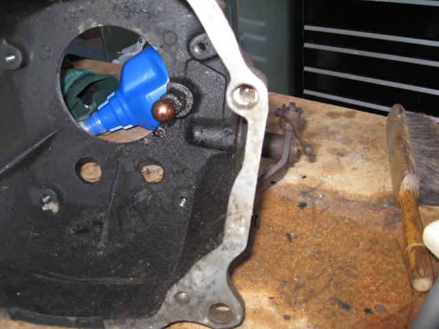 Close-up of a vehicle's clutch fork and bell housing with a blue bottle inside