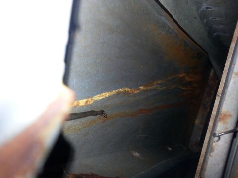 1992 Ford Bronco - The interior of a vehicle shows significant rust damage along a metal channel.