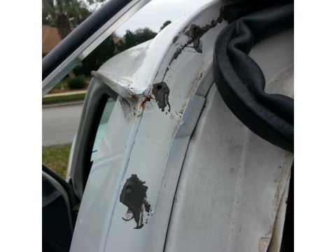 1992 Ford Bronco - Rust damage is visible on the drip rail and adjacent bodywork of the vehicle.