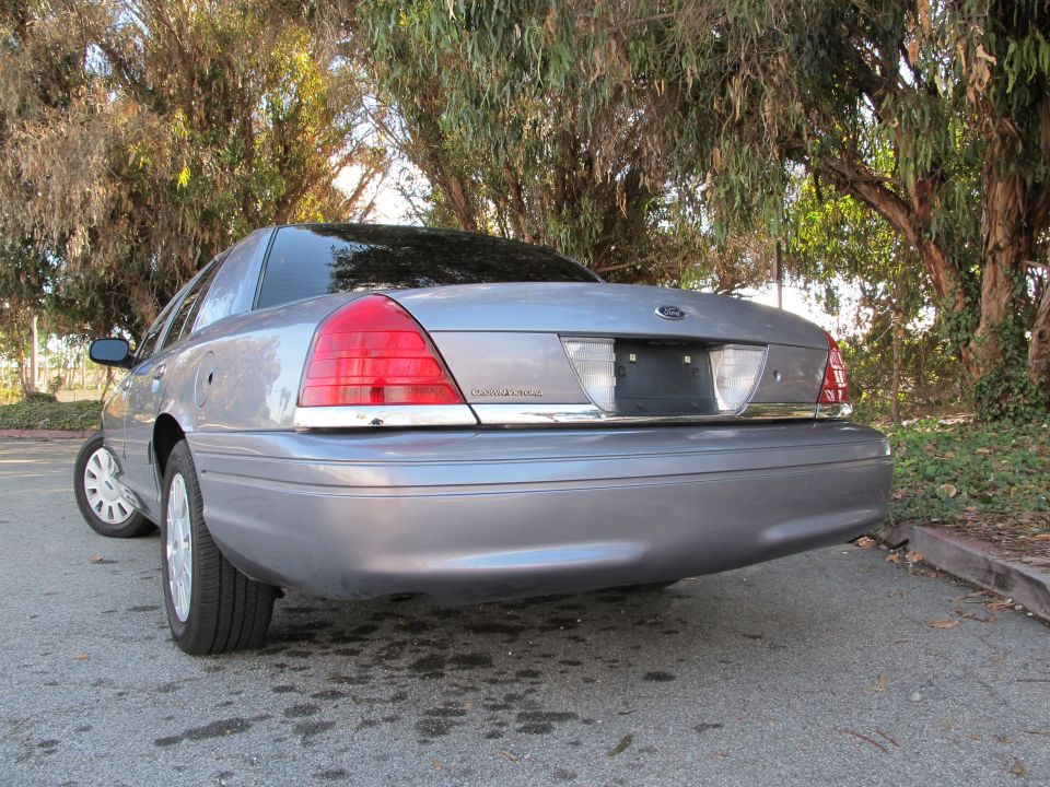 Silver 2006 Ford Crown Victoria rear view. Chrome trim surrounds the license plate area and taillights