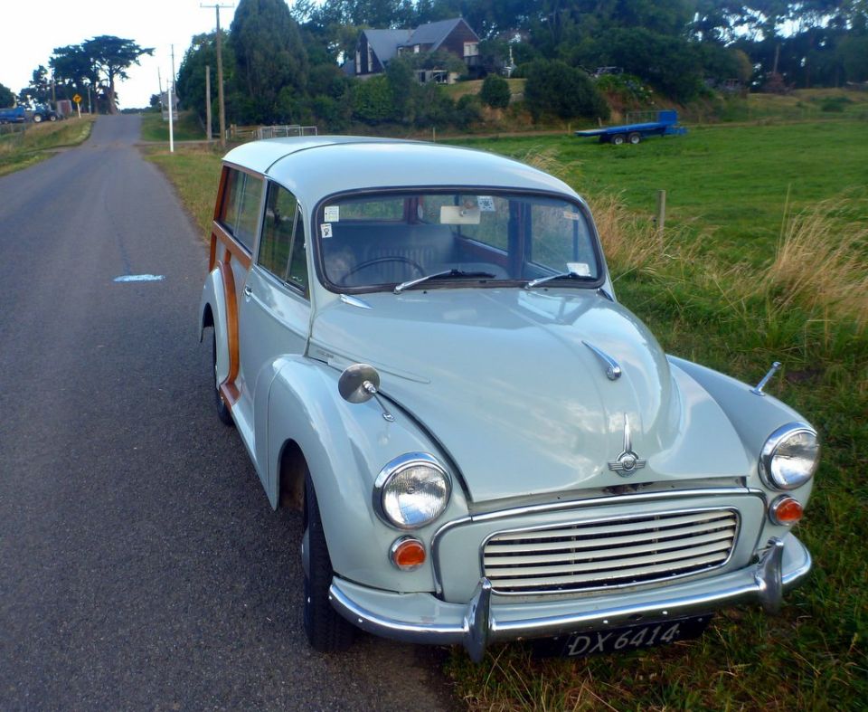 Light blue Morris Minor Traveller with wood paneling parked on a roadside