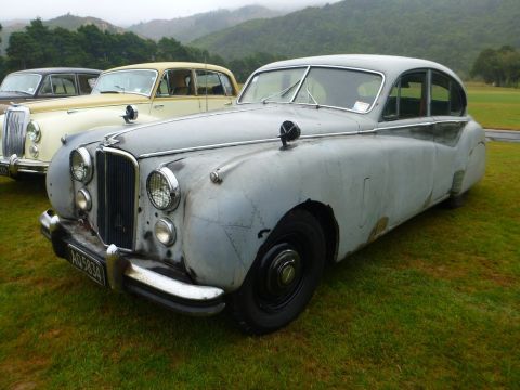 1969 MINI Cooper - A classic Jaguar Mark IV, likely from the late 1940s, is shown in a three-quarter front view, parked alongside other vintage vehicles.