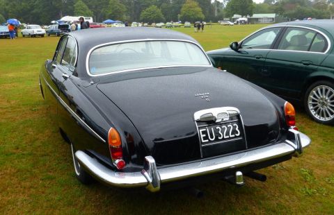 1969 MINI Cooper - A classic black Jaguar 420 G is seen from the rear at an outdoor car show.