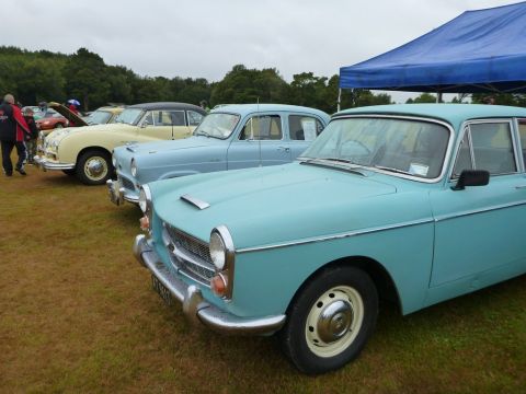 1969 MINI Cooper - Several classic cars are lined up on a grassy field under a blue tent.