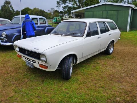 1969 MINI Cooper - This white station wagon, possibly a 1973 model, is parked on a grassy field next to another vehicle.