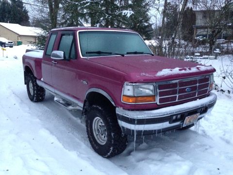 1992 Ford F-150 - A maroon Ford F-150 pickup truck is parked in the snow, showing icicles hanging from its front bumper.