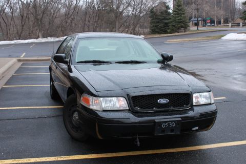 2005 Ford Crown Victoria - This black Ford Crown Victoria is parked in an outdoor lot on a cloudy day.