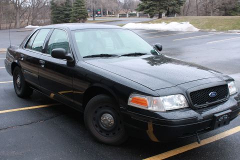 2005 Ford Crown Victoria - A black 2005 Ford Crown Victoria is parked in a lot, showing its front passenger side.