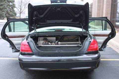2005 Ford Crown Victoria - Trunk of a 2005 Ford Crown Victoria open, revealing aftermarket equipment installed.