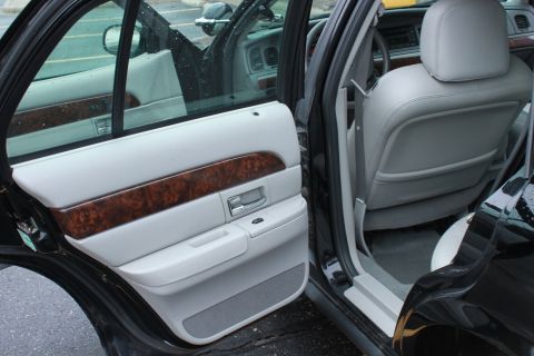2005 Ford Crown Victoria - Interior view of a 2005 Ford Crown Victoria, focusing on the door panel and rear seating area.