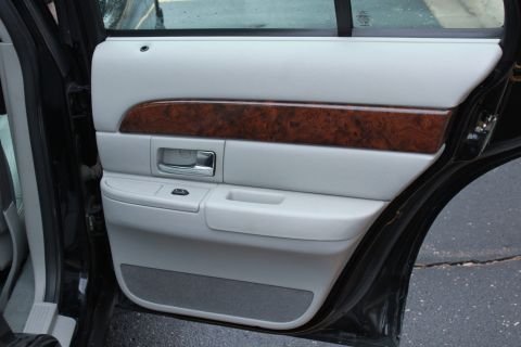 2005 Ford Crown Victoria - Close-up of a car's interior door panel, showing the armrest and door handle.