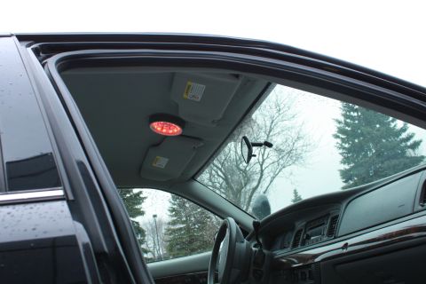 2005 Ford Crown Victoria - The interior of a police vehicle is shown, a red emergency light mounted on the ceiling and a watermark from Supermotors.net.