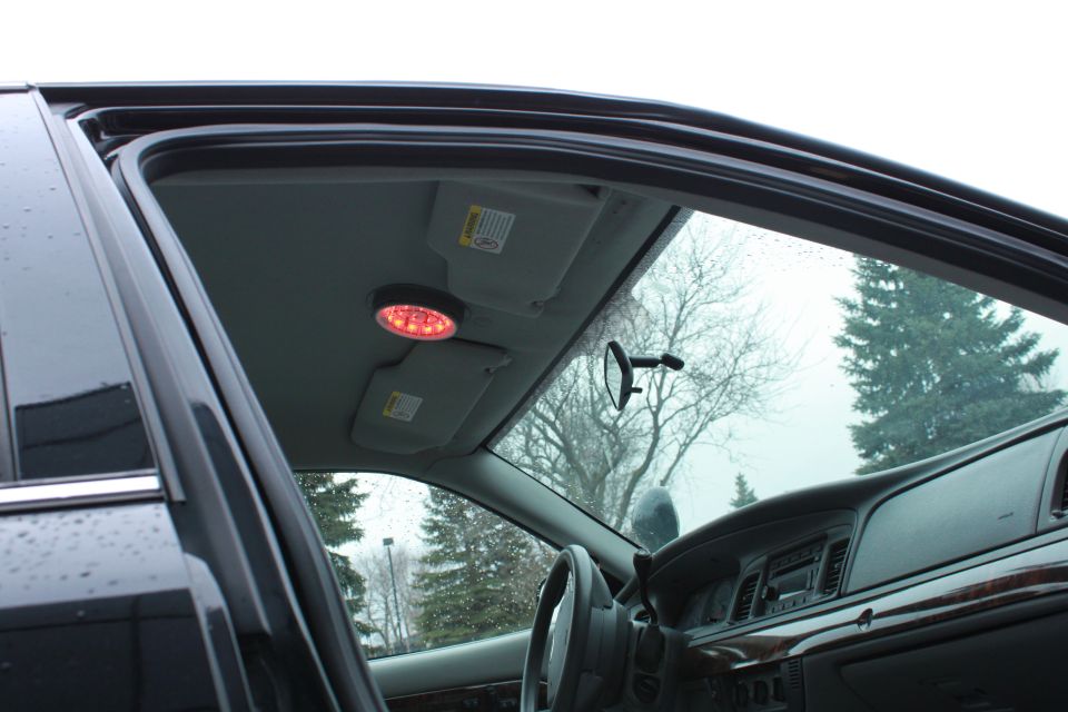 Interior view of a police car with a red overhead emergency light and a Supermotors.net watermark