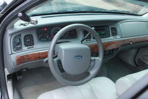 2005 Ford Crown Victoria - The interior of a 2005 Ford Crown Victoria shows the dashboard, steering wheel, and front seats.
